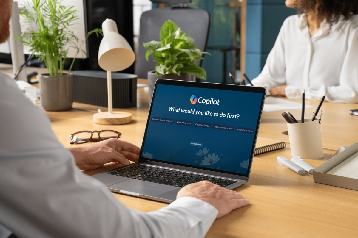 Microsoft Copilot training showing a business professional using Copilot on a laptop in a workplace setting